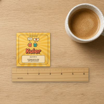 Kuier magnet (Sunshine): Top-down on oak with inch ruler (real marks), coffee mug and kraft paper