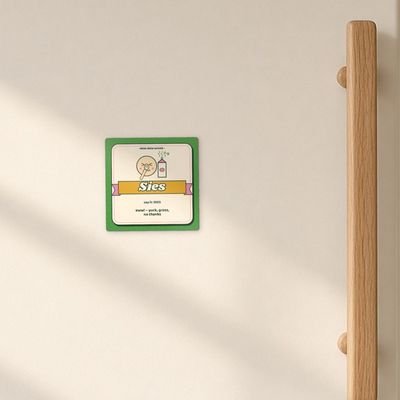 Sies magnet (Veld): Cream enamel fridge door in morning window light, oak handle
