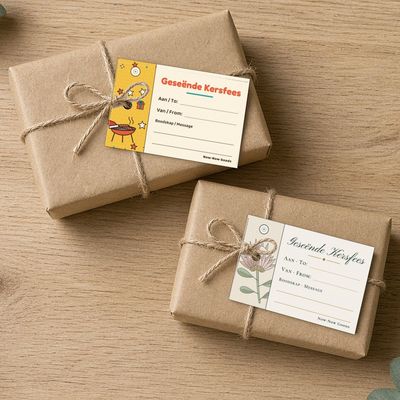 Digital printable gift tags: Top-down: printed tags (Braai Kersfees, Koningsprotea) on kraft-wrapped gifts with jute twine bows, eucalyptus, oak